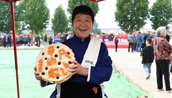 In pics: Bountiful autumn harvest celebrated across China 	 	A villager displays a steamed bun during a celebration for the seventh Chinese farmers' harvest festival in Beizhai village, Shaoyuan township, Jiyuan city, central China's Henan Province, Sept. 22, 2024.